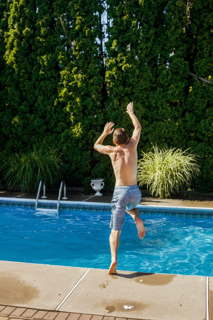 child jumping into heated pool